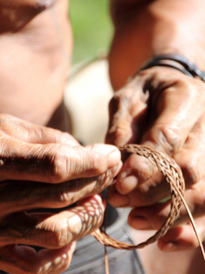 Homme mentawai qui fabrique un bracelet